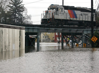 A NJ Transit commuter train travels over a flooded underpass in Garfield, New Jersey